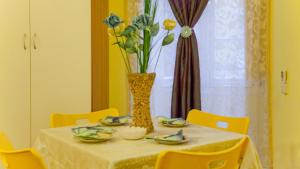 ローマにあるRental in Rome Sardegna Apartmentの黄色い椅子と花瓶
