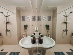 un bagno con lavandino con piante in vaso di 2BR Penthouse with Wide Balcony and 7ft Billiards The Polaris Penthouse at Azure North a San Fernando