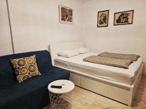 a small bedroom with a bed and a couch at Studio Apartments Siesta in Sarajevo