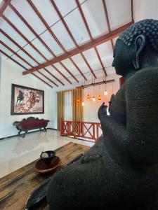 a statue of a woman sitting on the floor in a room at White Horse in Hikkaduwa