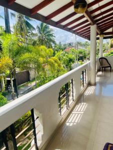 a balcony of a house with a view of trees at White Horse in Hikkaduwa