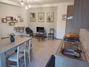 a kitchen with a sink and a counter with chairs at A casa di Ester appartamento in Passo Corese
