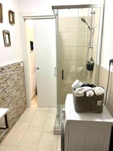 y baño con ducha y bañera con toallas. en Elena s Home piano primo, en Chioggia
