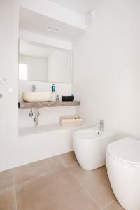 a white bathroom with a tub and a sink at Cali Suites Mergellina in Naples