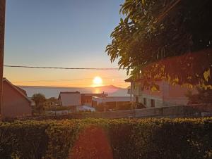 a sunset over a city with houses and the ocean at Paradise in Vigo in Vigo