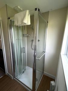 eine Dusche mit Glastür im Badezimmer in der Unterkunft Fern Cottage in Brinklow