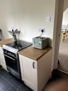 eine Küche mit Herd und Arbeitsplatte in der Unterkunft Fern Cottage in Brinklow