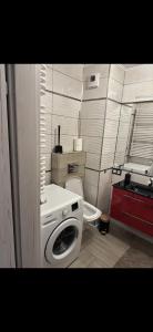 a bathroom with a washing machine and a toilet at Family Apartament in Zamość