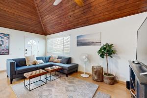 a living room with a blue couch and a wooden ceiling at Venice Delight in Los Angeles