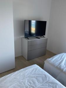 a bedroom with a flat screen tv on a dresser at Casa Cotone 5 in Marciana Marina