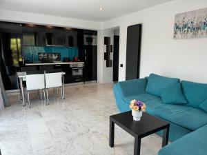 a living room with a blue couch and a table at R&B Apartment 24 in Predeal