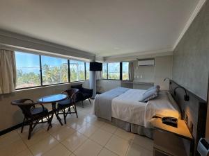 a bedroom with a bed and a table and chairs at Atlântico Praia Hotel in João Pessoa +60 photos
