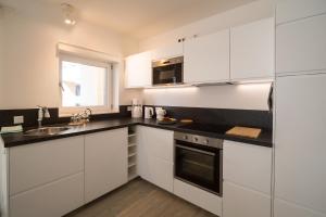a kitchen with white cabinets and a sink at Goldsprotte in Eckernförde