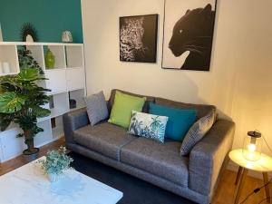 a living room with a couch with green and blue pillows at Jungle Chic in Courcouronnes