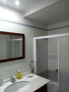 a bathroom with a sink and a shower and a mirror at ΤΕΣΣΑΡΙ ΣΤΟΝ ΝΑΥΤΙΚΟ ΟΜΙΛΟ Χíου in Chios