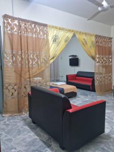 a living room with two couches and a couch at PD BATU 9 Cocobay Resort Condominium in Kampong Tanah Merah