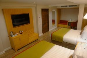 a hotel room with two beds and a flat screen tv at Iguazu Jungle Lodge in Puerto Iguazú