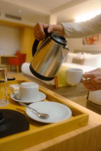 a person is holding a tea kettle on a table at Iguazu Jungle Lodge in Puerto Iguazú