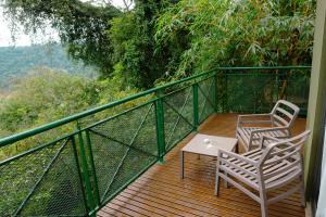 two chairs and a table on a wooden deck at Iguazu Jungle Lodge in Puerto Iguazú
