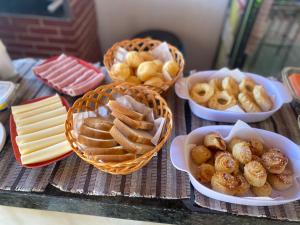 a table topped with bowls of food and baskets of snacks at pousada vila das oliveiras in Pirenópolis