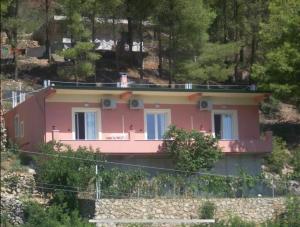 a pink house on the side of a hill at Vila Frroku in Shëngjin