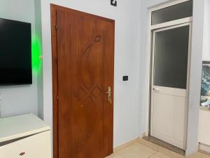 a wooden door in a room with a television at Vila Frroku in Shëngjin