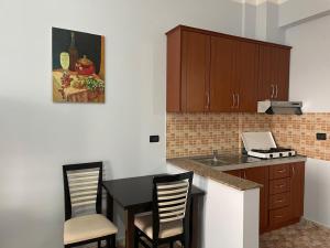 a kitchen with a table and chairs and a sink at Vila Frroku in Shëngjin