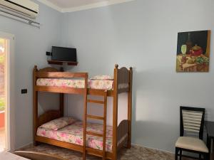 a room with two bunk beds and a television at Vila Frroku in Shëngjin