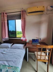 a bedroom with a bed and a desk with a laptop at 'Casa Sossegado' - 800 mts from Varca beach in Varca