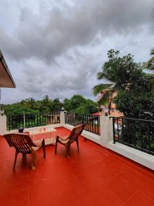 a patio with two chairs and a table on a balcony at 'Casa Sossegado' - 800 mts from Varca beach in Varca