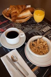 stół z miską płatków zbożowych, filiżanką kawy i chlebem w obiekcie Hôtel du Midi w mieście Domène