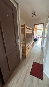 a room with a door and a bedroom with a bunk bed at En vacances, comme à la maison in La Joue du Loup