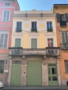 un bâtiment avec des portes de garage vertes dans une ville dans l'établissement Appartamento San Gallo Cremona Centro, à Crémone