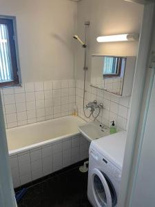 y baño con bañera y lavadora. en Asunto työporukalle Ollintie 1b2, en Uimaharju