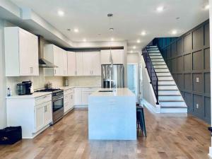 a kitchen with white cabinets and a staircase at Upscale 3BDR Penthouse with Rooftop TV and Stunning Capitol and Monument Views Near Popular H Street Corridor Parking Included Free Cancellation in Washington