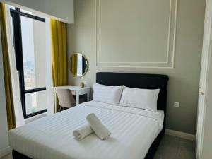a bedroom with a bed with two towels on it at Axon Serviced Suites Kuala Lumpur in Kuala Lumpur +57 photos