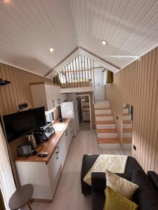 a living room with a couch and a kitchen and stairs at Söğüt HOUSES in Marmaris