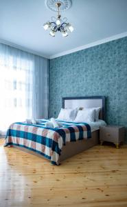 a bedroom with a bed with a checkered blanket at Cool Family House Gabala in Gabala