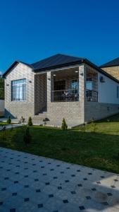 a house with a black roof on top of a yard at Cool Family House Gabala in Gabala
