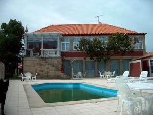 a house with a swimming pool in front of a house at Falcao de Mendonca in Figueira de Castelo Rodrigo