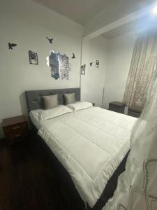 a bedroom with a large bed with white sheets at Noor Lyang in Gangtok