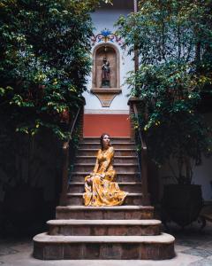 a statue sitting on steps in front of a building at Parador Santa Maria La Real in Sucre