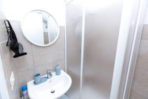 a bathroom with a sink and a mirror and a shower at Light Blue in Anguillara Sabazia +24 photos