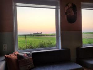 a room with a window with a view of a field at Dijksterhuisje in Pieterburen