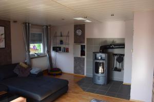 a living room with a couch and a stove at Ferienwohnung am Schwalmufer in Schwalmstadt