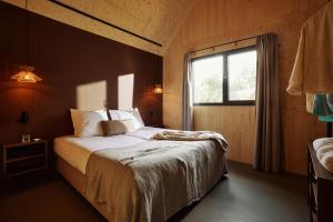 RoldeResort Roodewoud的一间带大床的卧室，带窗户