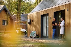 RoldeResort Roodewoud的两个人站在建筑物外面
