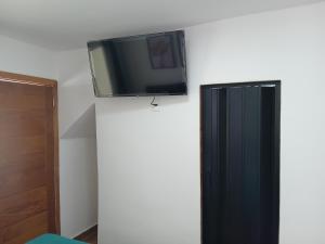 a flat screen tv on top of a wall at kitnet com garagem exclusiva in Venda Nova