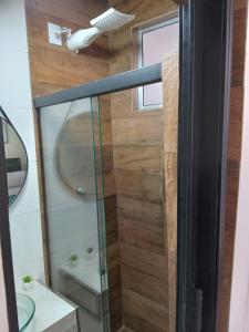 a shower with a glass door in a bathroom at kitnet com garagem exclusiva in Venda Nova +6 photos