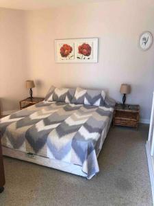a bedroom with a bed and two tables with lamps at Condominio San Alfonso del Mar in Mirasol